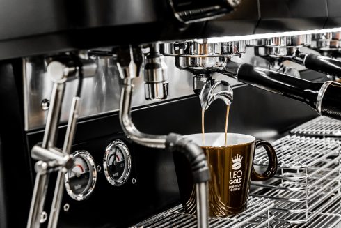 Capuchino fließt sahnig in eine Tasse